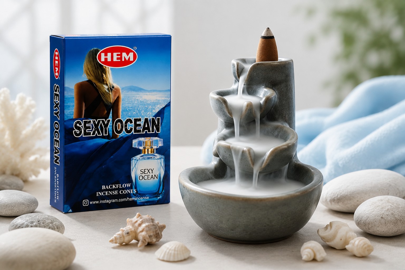 عود آبشاری رایحه سکسی اوشن (Sexy Ocean) | برند HEM 1 عود آبشاری HEM با رایحه سکسی اوشن در حال سوختن روی جاعودی آبشاری در فضایی روشن و دریایی